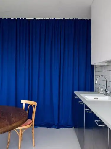 瓷砖,而在洗手台的配色上,则对应了隐藏储藏室宝蓝色窗帘的高级配色