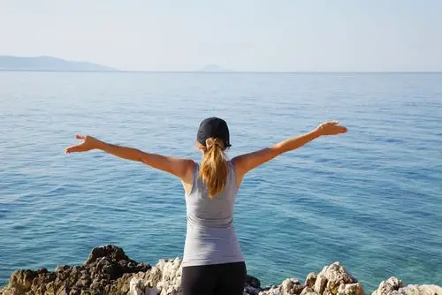 海边展开双手的美女