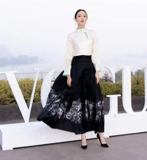 童瑶上身穿白色衬衣,下身搭配黑色的印花裙,脚踩黑色尖头高跟鞋,气质