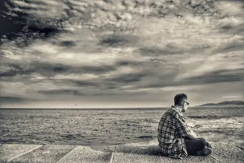 坐在坝堤上的一个孤独的老人,抓拍,偷拍