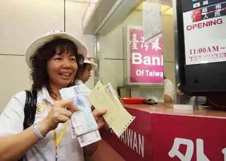 大陆观光首发团四日来台,广东旅客拿人民币兑换新台币时,心情相当