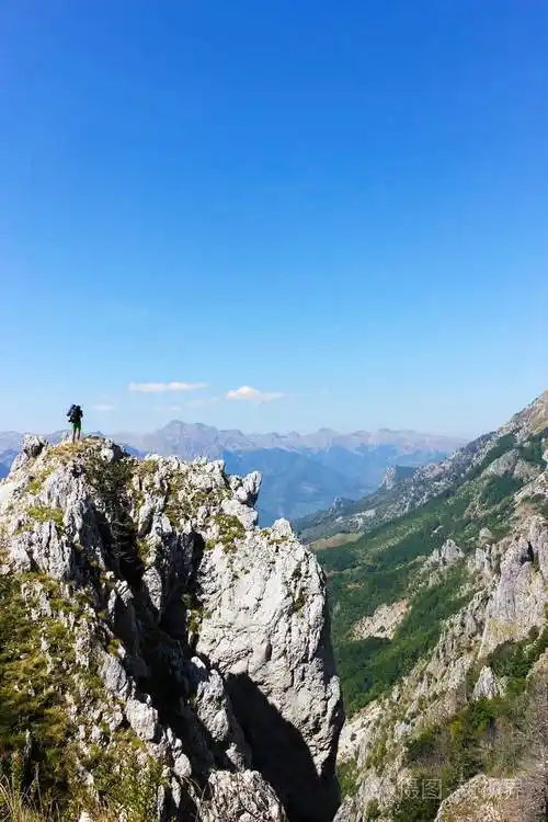 一个人站在山顶上向前看