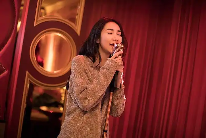 快乐的年轻女士在ktv唱歌