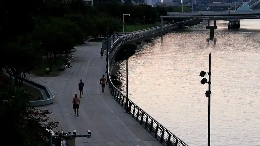 清晨江边的散步跑步者