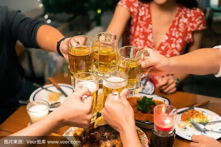 亚洲人晚上在家聚餐,喝啤酒.