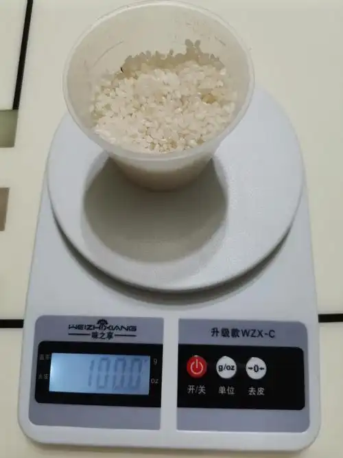 我找来量米的杯和电子秤,先称出100克米,自己动手烧饭.