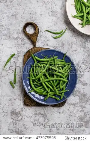 french bean in blue plate on old wooden board on the rough light
