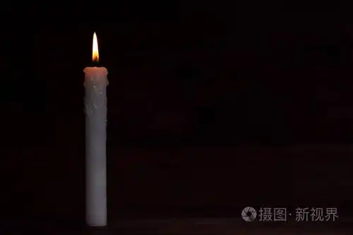 黑色背景上的白色燃烧蜡烛