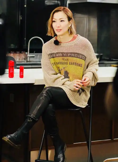 47岁郑秀文身穿黑色针织衫加上休闲裤,脚上搭配运动鞋,时尚气质