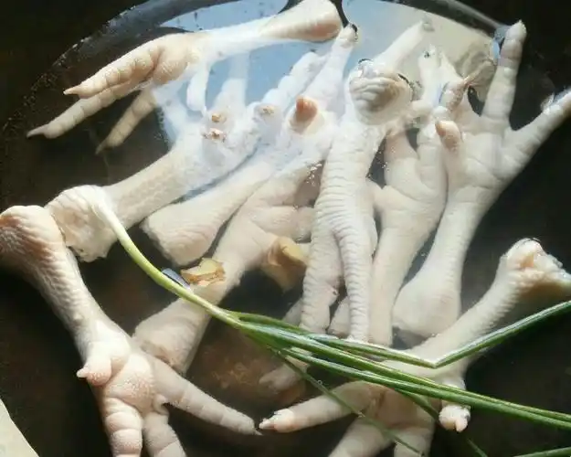 1,提前准备一盆冰水备用,鸡脚洗净冷水下锅放姜片,料酒,葱,鸡脚大火煮