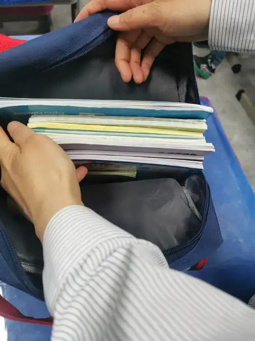 老师给孩子们示范如何整理书包,学习用具,还有一些自己的衣服,帽子