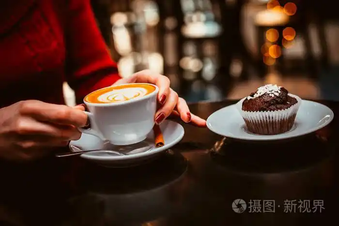 在一家咖啡馆喝咖啡的女孩