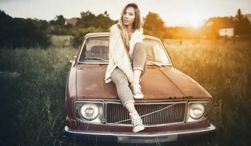 坐在老爷车头的美女