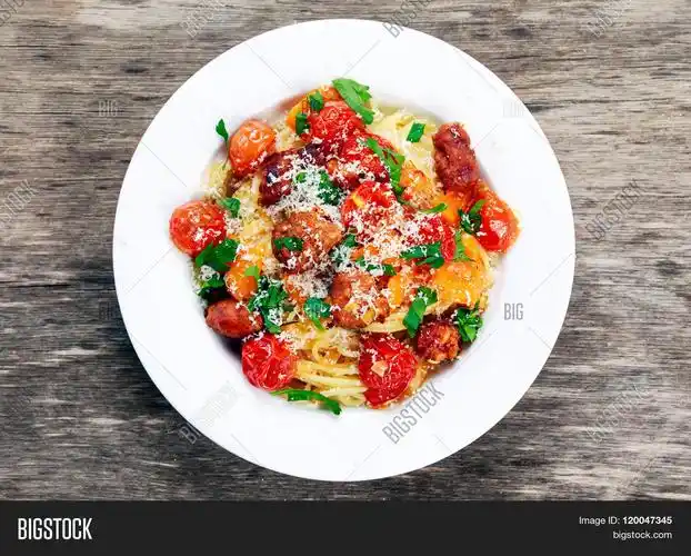 sausage pasta spaghetti with summer vegetables on plate