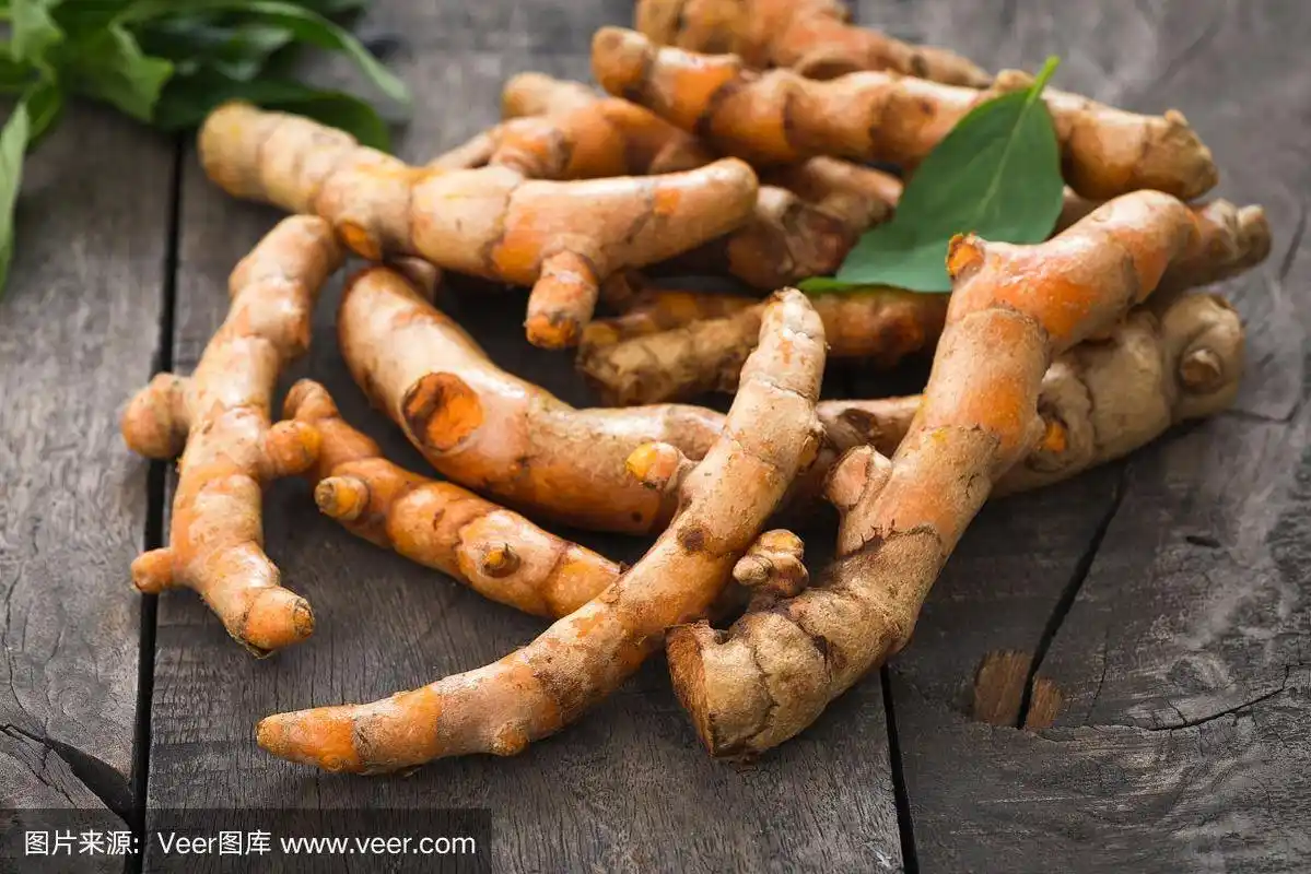 新鲜姜黄根放在木桌上