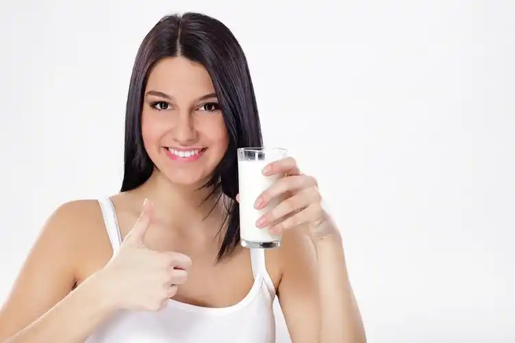 白色背景微笑的女人手里拿着一杯牛奶woman with a glass of milk