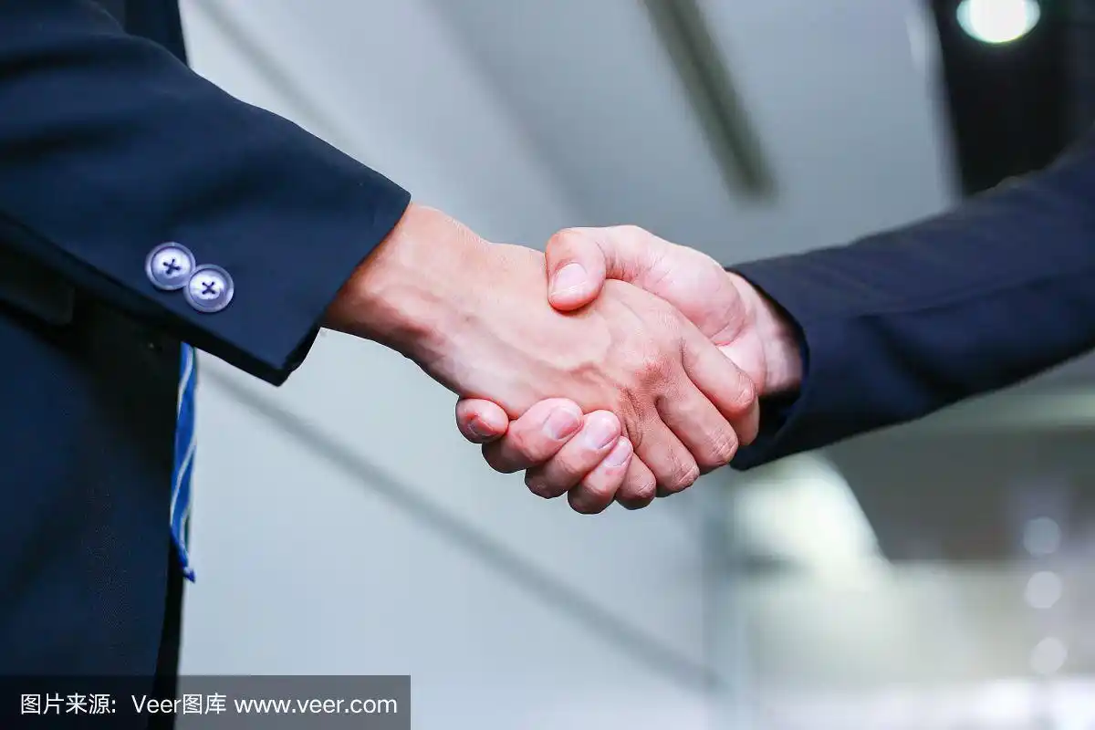 商务人士在办公室握手——商务成功,礼仪,祝贺,并购的概念.