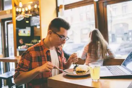 男人在一家餐馆吃饭,享受美味的食物照片