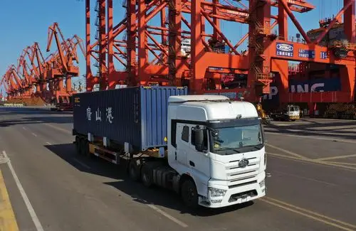 一辆无人驾驶集装箱卡车在唐山港京唐港区集装箱码头运送集装箱