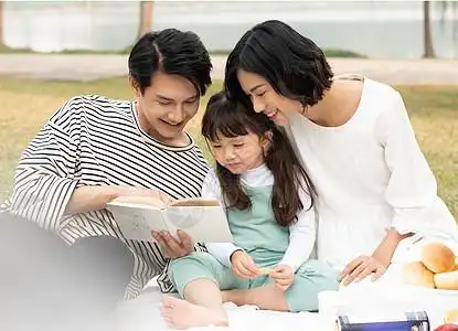 父母陪伴孩子在户外阅读图片素材