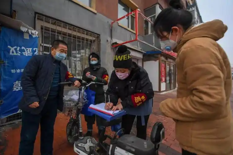 青浦社区,志愿者常树林,杨清,于雪梅(从左至右)为外出居民办理出入证