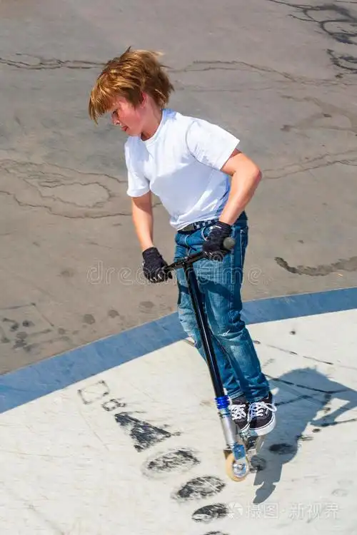 男孩在滑冰公园玩推滑板车的跳跃很有趣