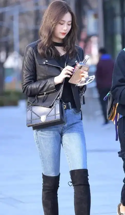 高颜值小姐姐身穿黑色皮衣夹克搭配黑色长筒靴,又甜又酷.