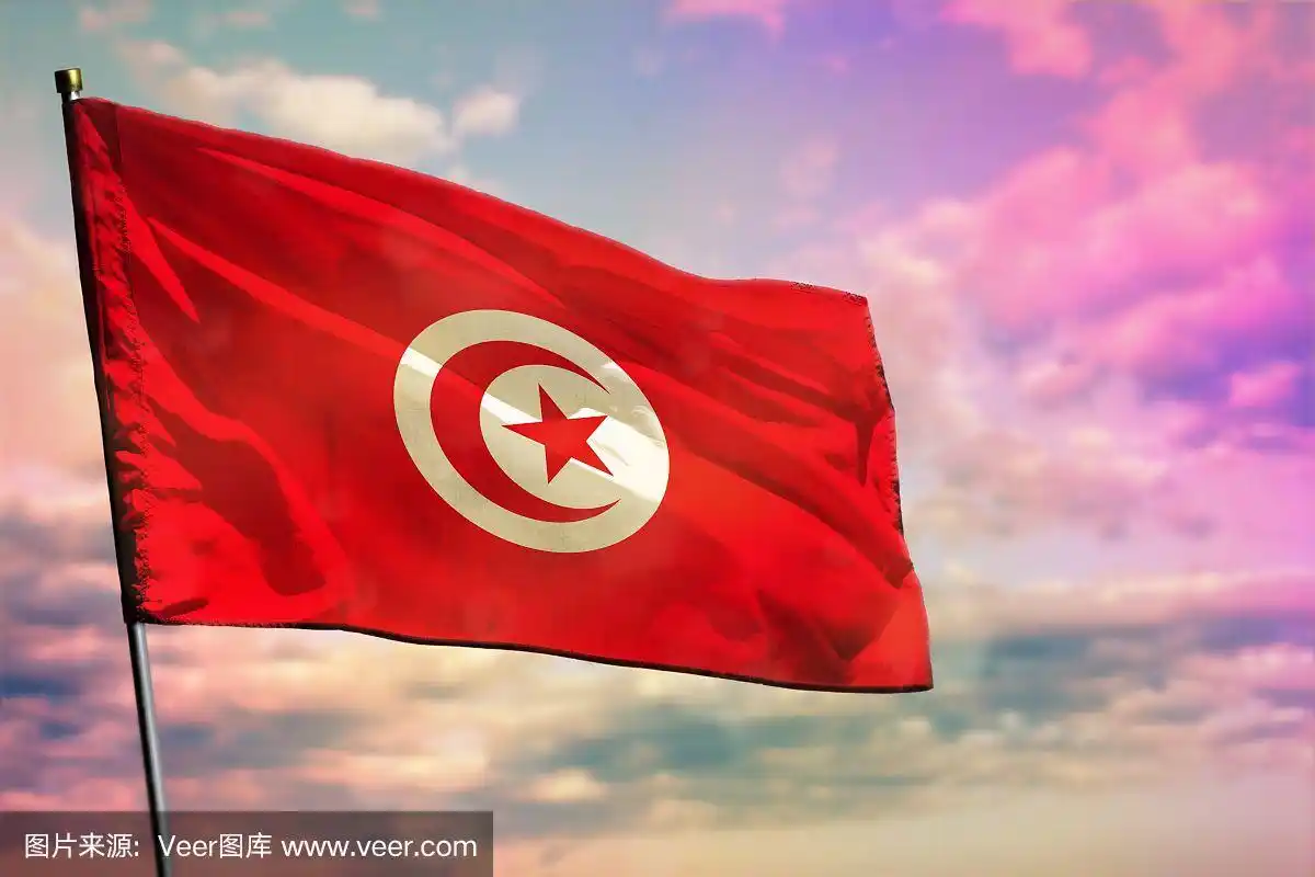 飘扬的突尼斯国旗以五彩多云的天空为背景.繁荣的概念.