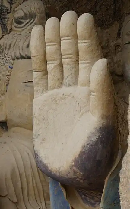 右手齐肩举起,掌心向外,作施无畏印(手印表示了佛为救济众生的大慈悲