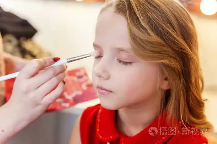 模特涂上眼影专业化妆由艺术家申请在过程中弥补细节时尚儿童美容院