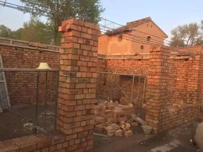 一个日头快要落山的下午房子前后左右砖墙起来了.
