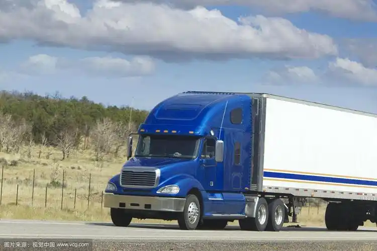 一辆蓝色前轮白色车身的十八轮大卡车