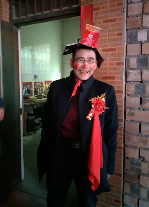 被画上花脸的新郎爸爸满脸喜气