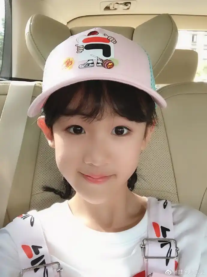 照片中,她戴着粉色帽子,身穿粉色背带裤,皮肤白皙可爱十足.