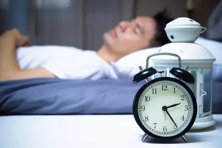 人睡在卧室里的女人忧虑哀伤的年轻有吸引力的人醒着躺在床上睡不着