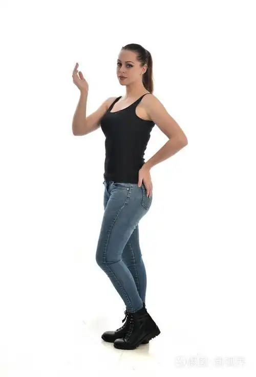 穿黑色单身牛仔裤的黑发女孩的全长肖像. 站立姿势侧轮廓.