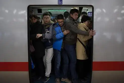 12月29日8时许,在北京地铁国贸站,市民挤上地铁.新华社记者 金立旺 摄