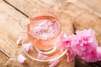 樱花茶,一杯新鲜的粉色樱花茶和樱花在桌子上