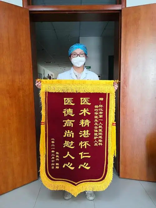 将印有这句话的锦旗送到杨巧华医生手中