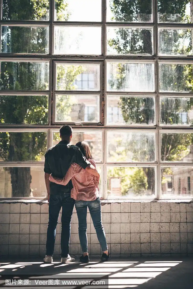 两个人拥抱着望着窗外