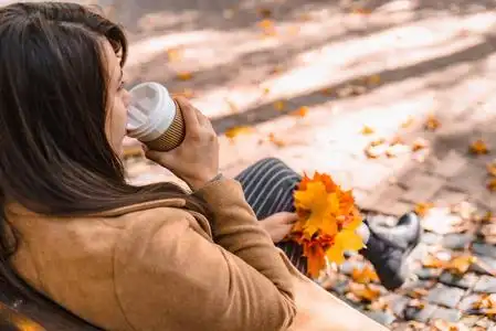 女人端着咖啡杯喝着去秋秋季节照片