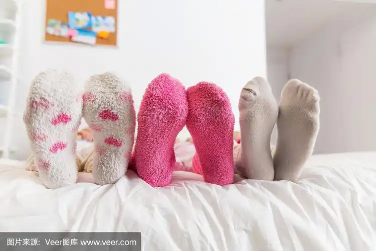 近距离的女人的脚在家里的床上袜子