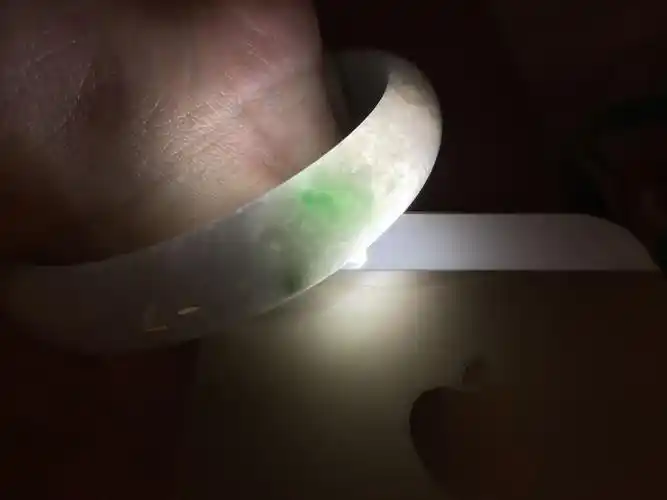 帮忙鉴定下这个手镯是不是a货 价格多少 灯光下白的区域带一点点浅浅