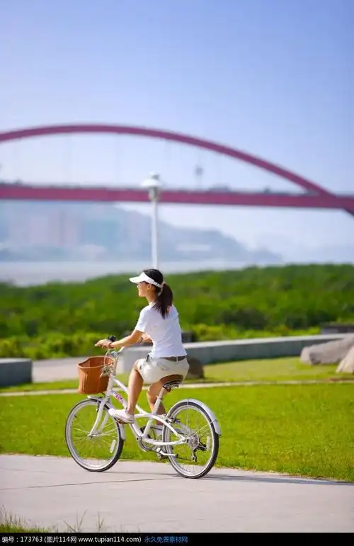 白色道路上骑自行车的美女