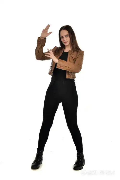 穿着棕色皮夹克的黑发女孩的全长肖像.在白色背景上站立姿势