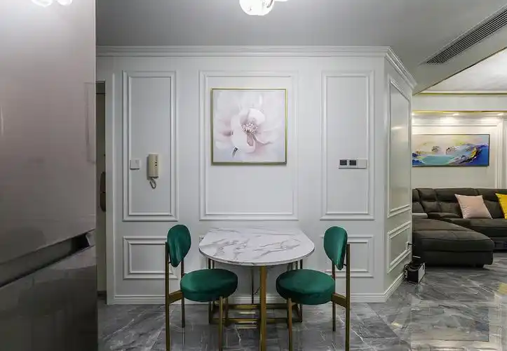 餐桌的那面墙,配上白色的护墙板,中间挂了一副粉色的挂画,配上有金属