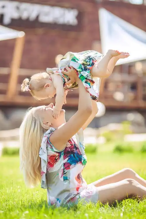 母亲抱着婴儿在夏天绿色公园的画像.户外活动