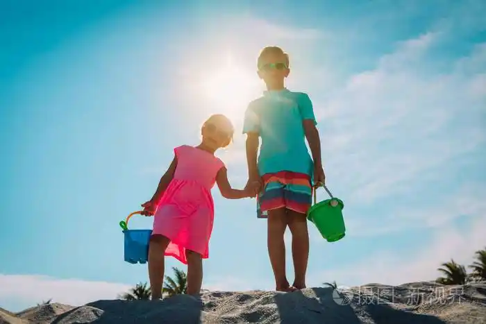 男孩和女孩在沙滩上玩沙子和玩具