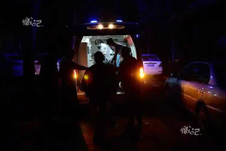 急救人员将老人抬上救护车.