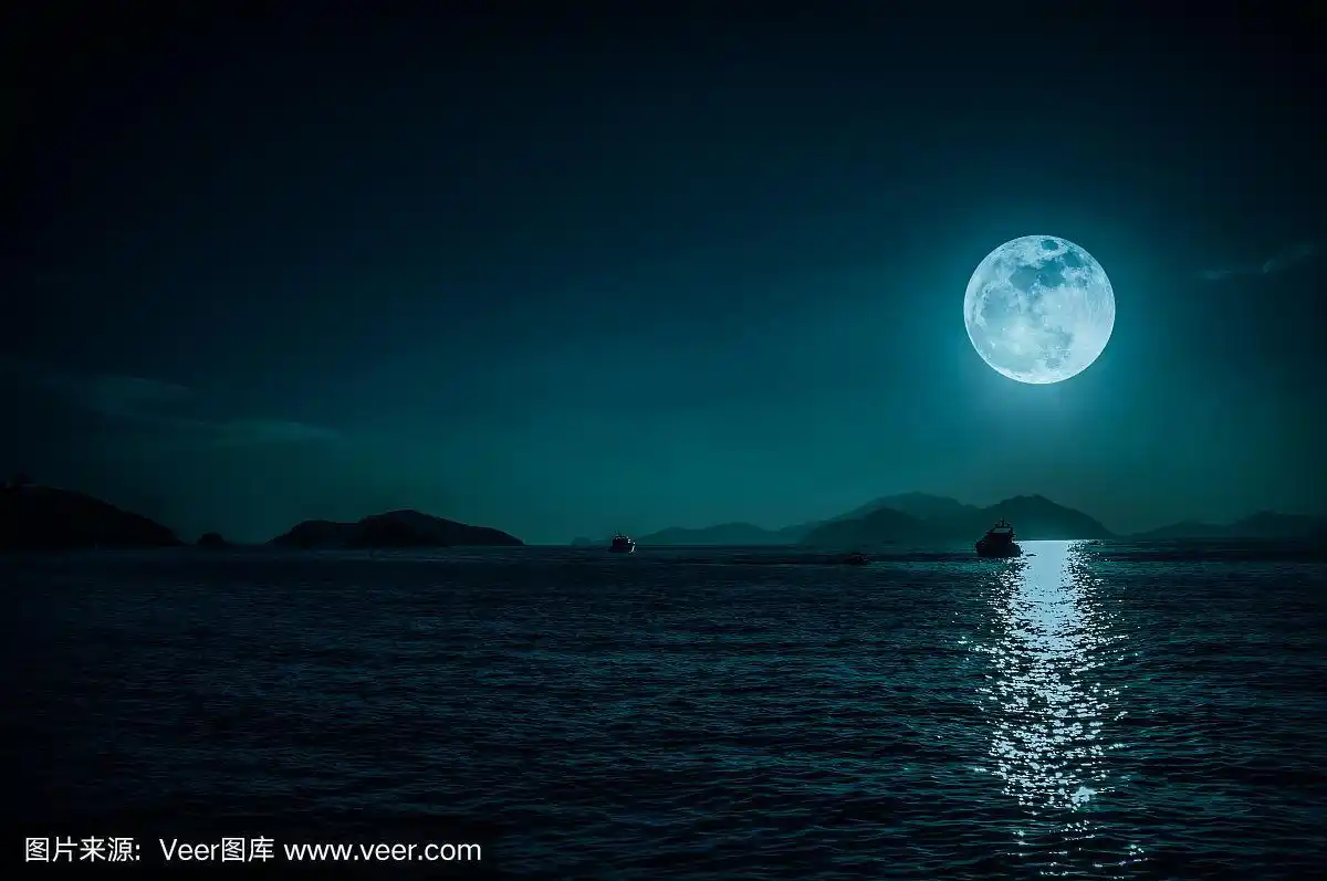 在夜晚的平静的海水和超级月亮的小船的风景.宁静的自然背景.